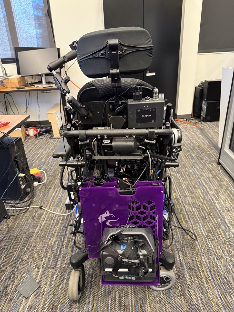 
                    The electronics mount hanging from a power wheelchair.
                    