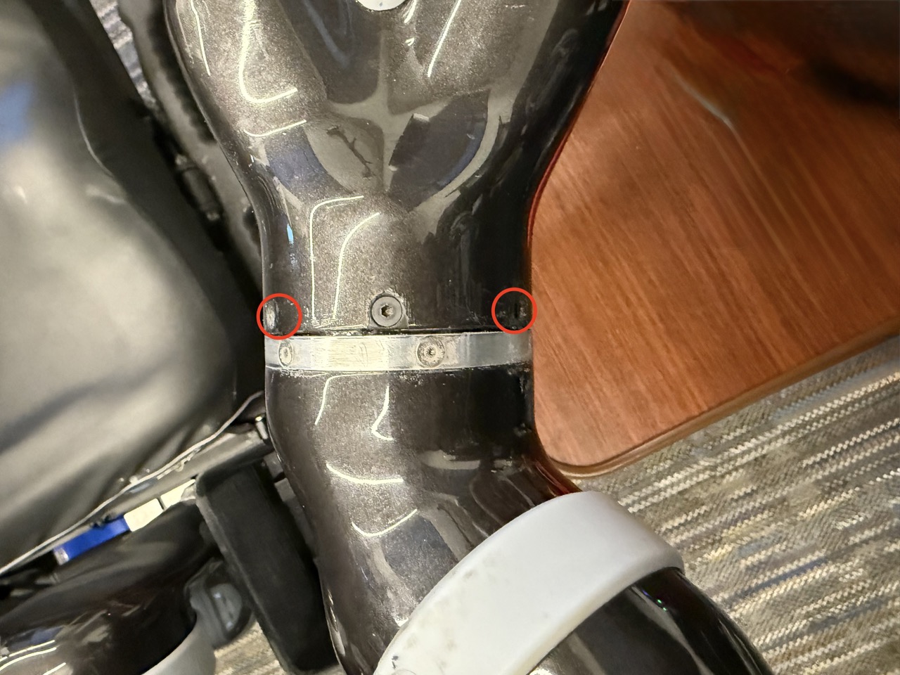 
                    This image shows the 6th joint of the robot arm, with the screws
                    on the left and right of the center screw circled and unscrewed.
                    