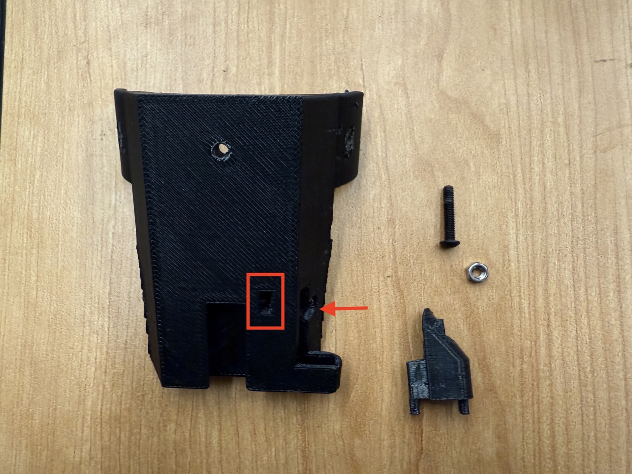 
                    This image shows the bottom of the fork assembly arm mount and the
                    mag cover, with the screw and nut location indicated in red.
                    