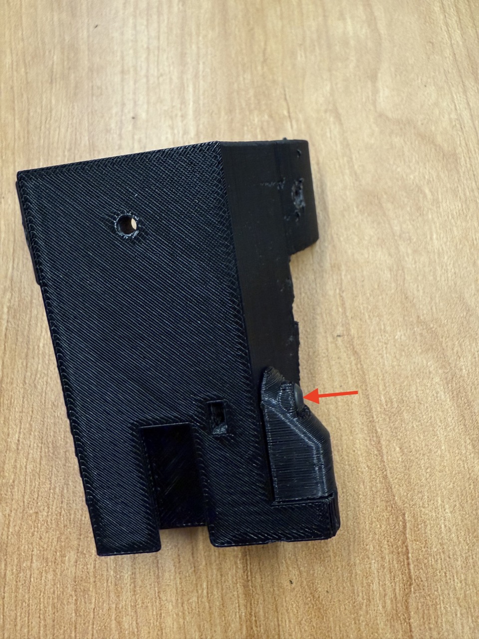 
                    This image shows the bottom of the fork assembly arm mount with
                    the mag cover attached. The screw is indicated with a red arrow.
                    