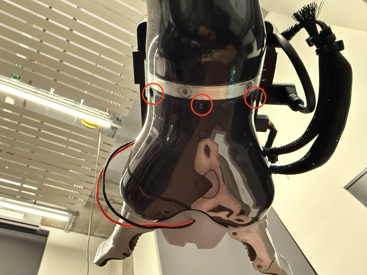 
                    This image shows the 6th joint of the robot arm, with the three
                    screws unscrewed. Red circles highlight the three screws.
                    