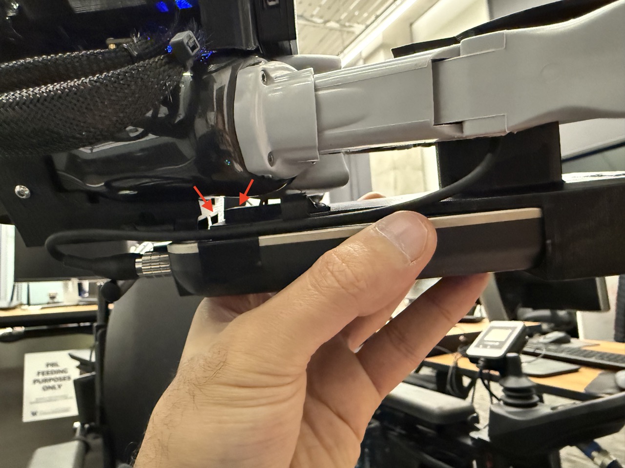 
                    A side-view of the fork assembly being slid into the robot arm's
                    gripper. Arrows show the trapezoidal extrusion on the wireless
                    F/T mountand the arm mount's corresponding trapezoidal slot.
                    