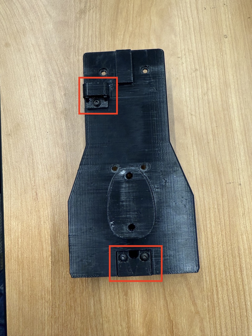 
                    This figure shows a photo of the wireless F/T mount, with the mag
                    cover and switch cover attached. The locations where the screws
                    attach are shown in red.
                    